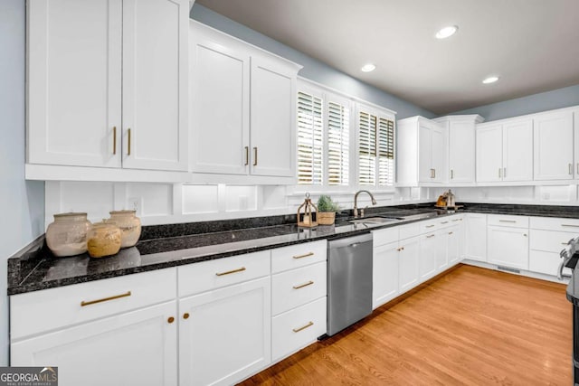 kitchen with a sink, white cabinetry, dark stone counters, light wood finished floors, and dishwasher