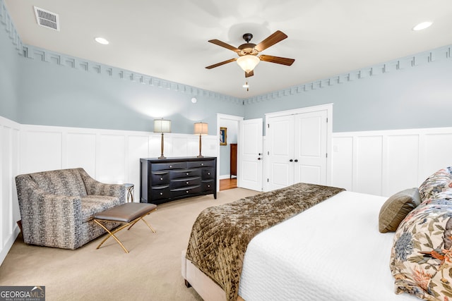 bedroom featuring visible vents, recessed lighting, ceiling fan, a decorative wall, and light colored carpet