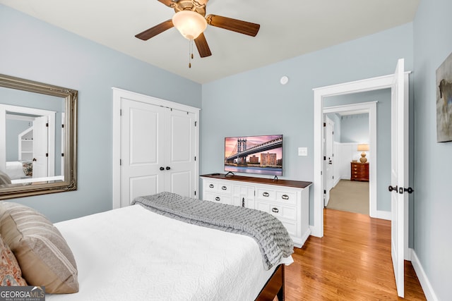 bedroom featuring a closet, baseboards, ceiling fan, and light wood finished floors