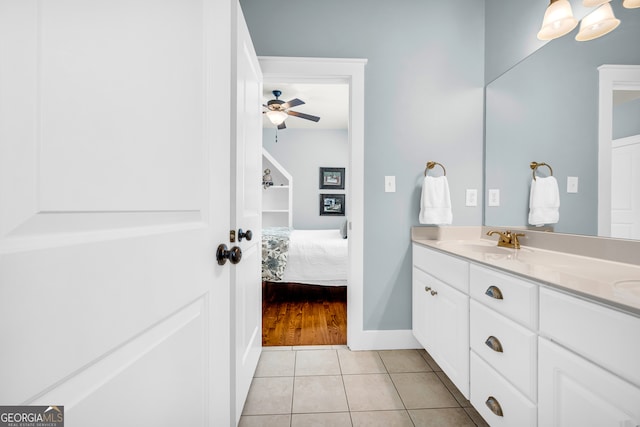 bathroom with a ceiling fan, connected bathroom, tile patterned flooring, baseboards, and vanity