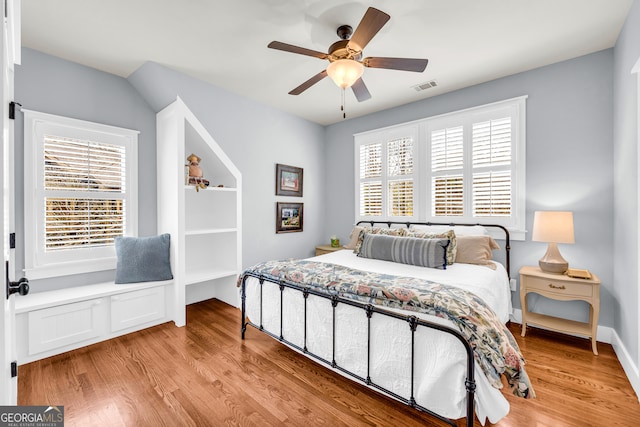 bedroom with ceiling fan, visible vents, and light wood-type flooring