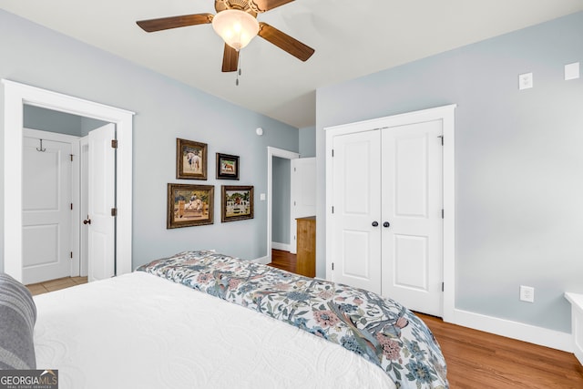 bedroom featuring ceiling fan, a closet, baseboards, and wood finished floors