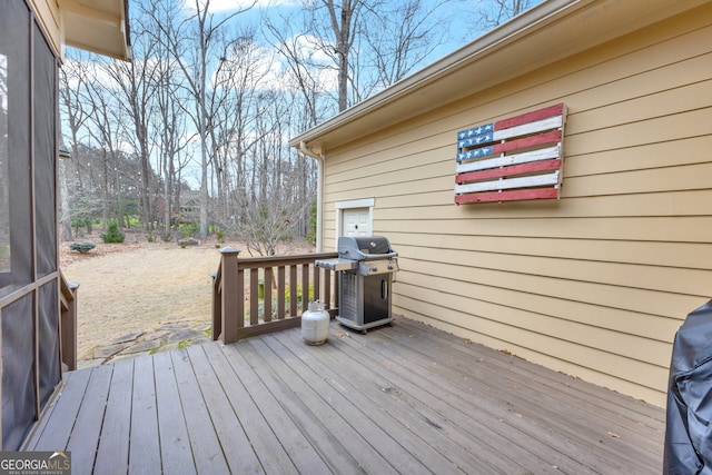 wooden deck featuring a grill