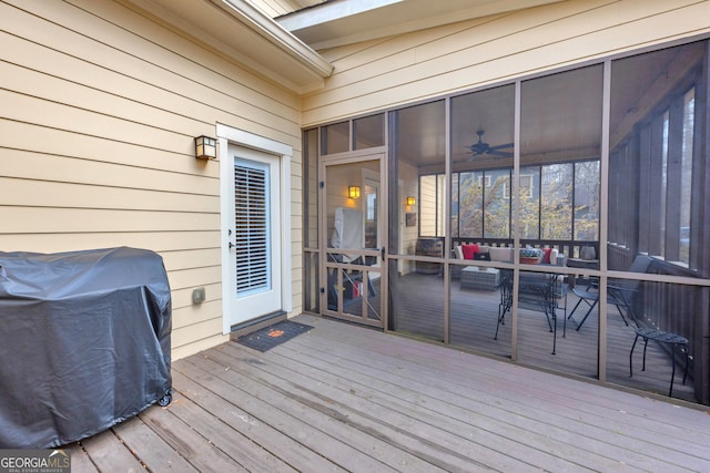 wooden deck with a sunroom and grilling area