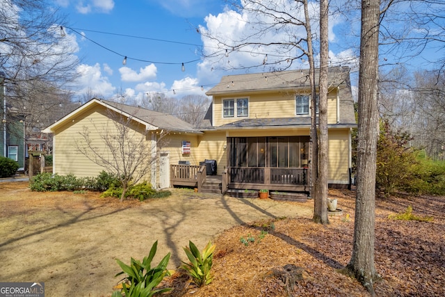 back of property featuring a sunroom and a wooden deck