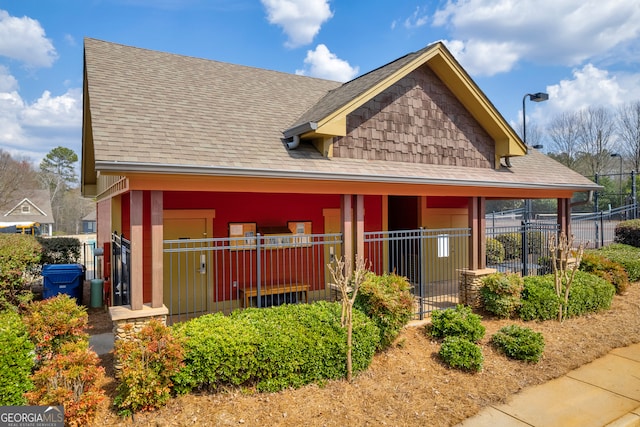 exterior space featuring fence and roof with shingles