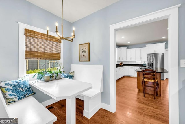 dining area with baseboards, a chandelier, breakfast area, light wood-type flooring, and recessed lighting