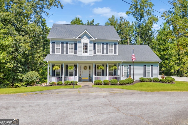 colonial inspired home with covered porch and a front lawn