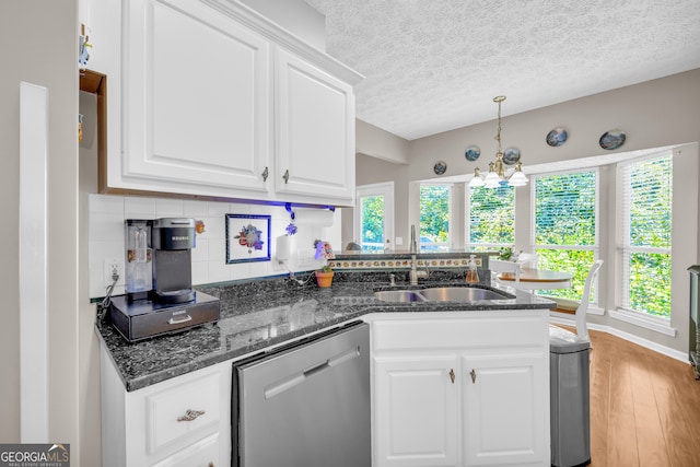 kitchen with stainless steel dishwasher, white cabinets, plenty of natural light, and a sink