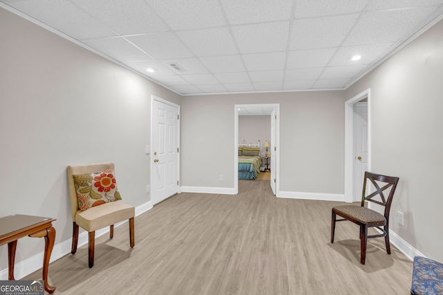 sitting room with visible vents, a paneled ceiling, baseboards, and light wood finished floors