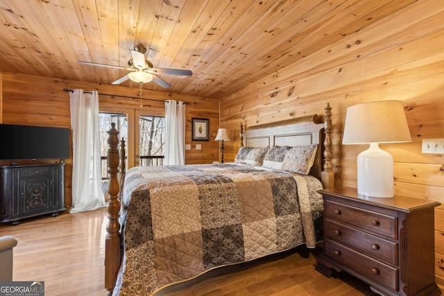 bedroom with access to outside, wood finished floors, wooden ceiling, wood walls, and ceiling fan