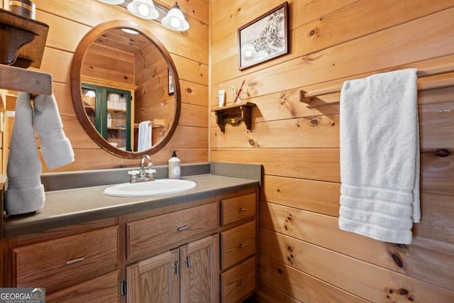 bathroom featuring wood walls and vanity