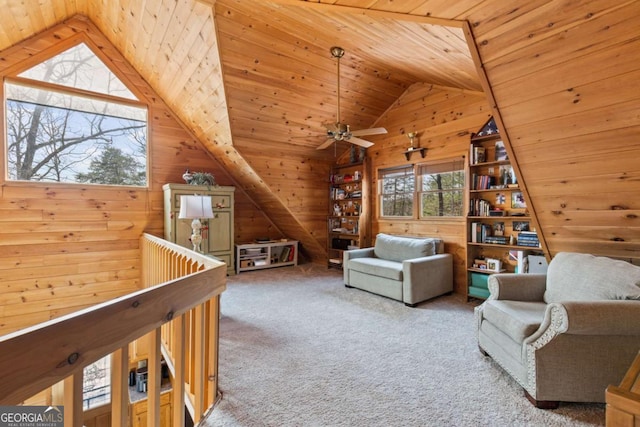 sitting room featuring a ceiling fan, wooden ceiling, wood walls, carpet flooring, and lofted ceiling