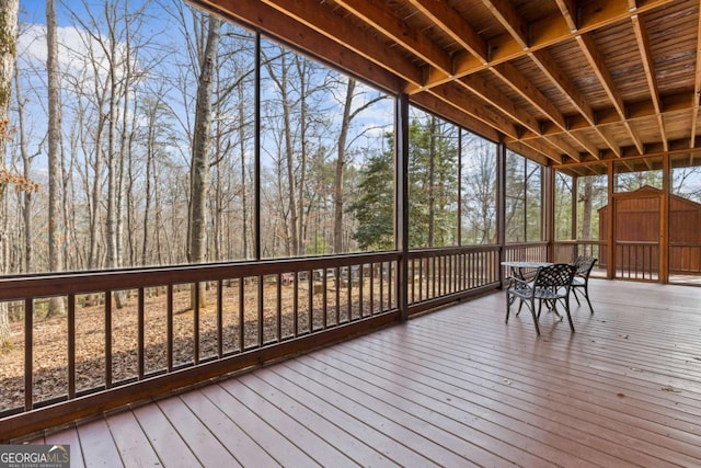 wooden deck with a storage shed and an outbuilding