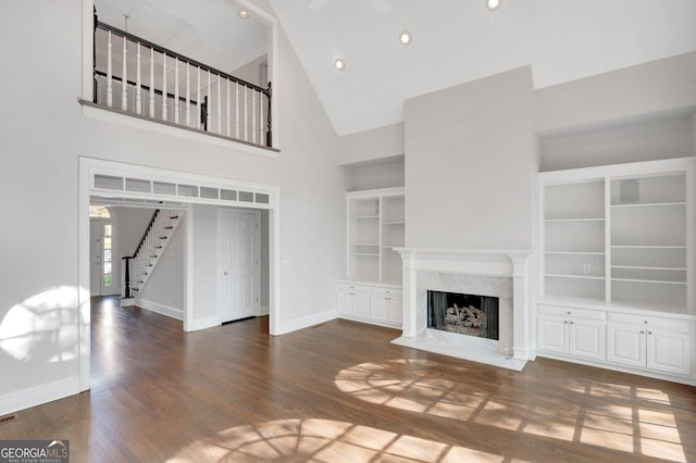 1139 Tennyson Pl NE, Brookhaven, GA 30319 - unfurnished living room featuring high vaulted ceiling, stairs, a premium fireplace, wood finished floors, and recessed lighting