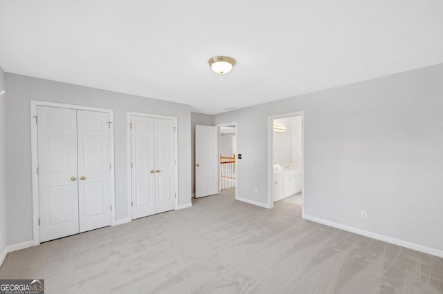 1139 Tennyson Pl NE, Brookhaven, GA 30319 - unfurnished bedroom featuring multiple closets, light carpet, and ensuite bathroom