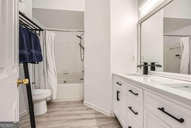 full bathroom featuring shower / tub combo with curtain, toilet, a sink, wood finished floors, and double vanity