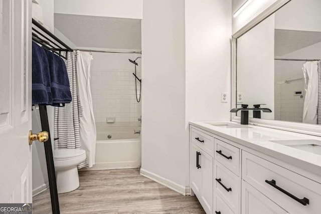 bathroom featuring shower / bathtub combination with curtain, toilet, a sink, wood finished floors, and double vanity