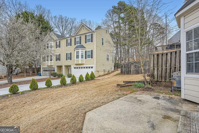 exterior space featuring fence and a garage