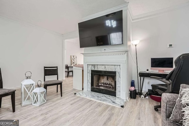 living area with crown molding, wood finished floors, and a premium fireplace