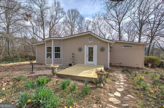 rear view of property featuring a wooden deck