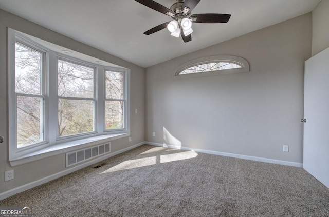 empty room with visible vents, lofted ceiling, baseboards, and carpet flooring