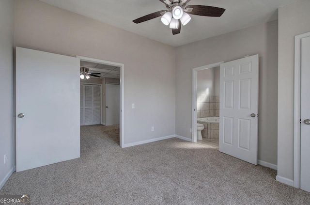 unfurnished bedroom featuring a walk in closet, baseboards, carpet, and connected bathroom