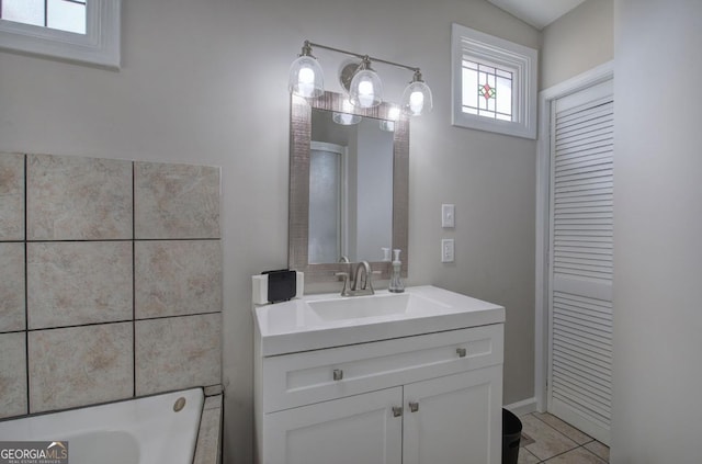 full bathroom featuring tile patterned floors, a bath, and vanity