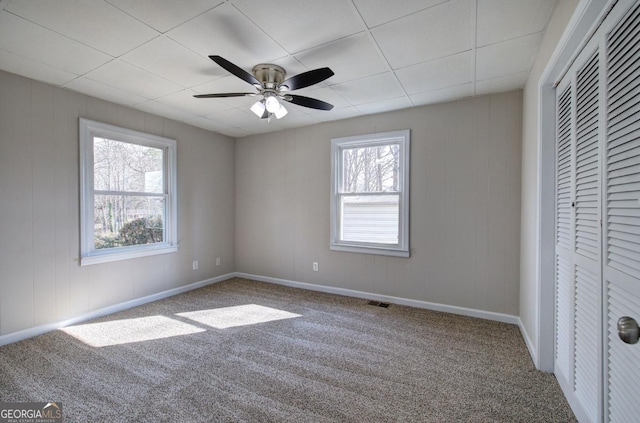 unfurnished bedroom with a closet, visible vents, ceiling fan, and carpet floors