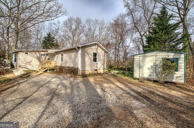 view of home's exterior with an outdoor structure, a shed, and crawl space