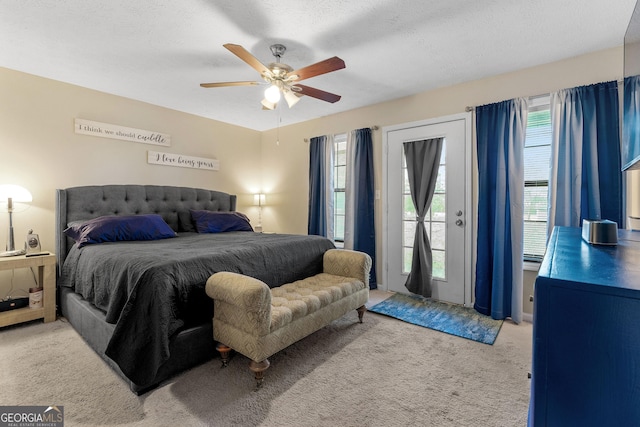 bedroom featuring a textured ceiling, light colored carpet, ceiling fan, and access to outside