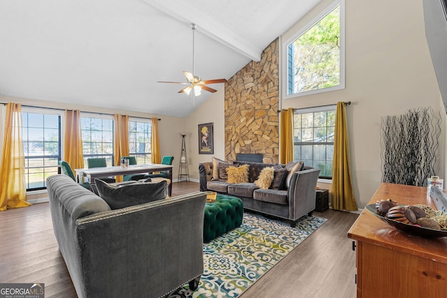 living room featuring a wealth of natural light, beam ceiling, and wood finished floors