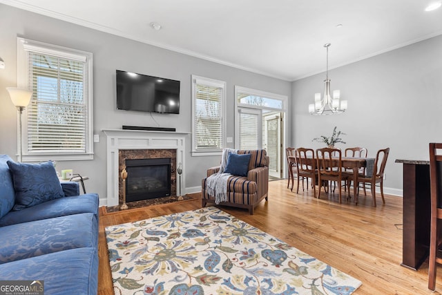 living area featuring a notable chandelier, wood finished floors, and crown molding