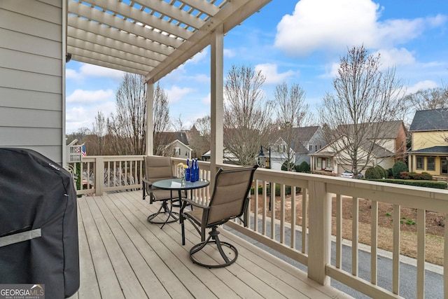 wooden deck with area for grilling, a pergola, and a residential view