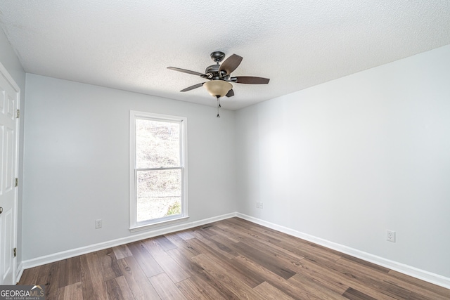 empty room featuring baseboards, a textured ceiling, dark wood-type flooring, and a ceiling fan