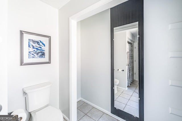 full bathroom featuring tile patterned flooring, toilet, and baseboards