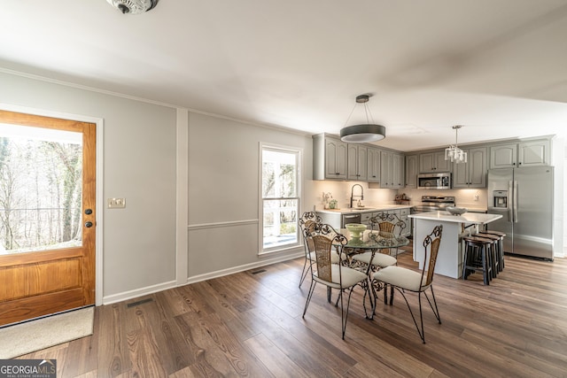 dining space featuring visible vents, baseboards, dark wood finished floors, and ornamental molding