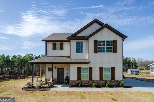 view of front of home with a porch, board and batten siding, a shingled roof, and fence