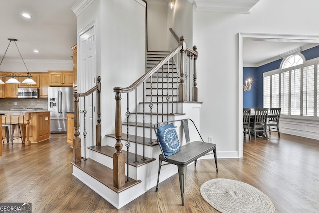 staircase with recessed lighting, crown molding, baseboards, and wood finished floors