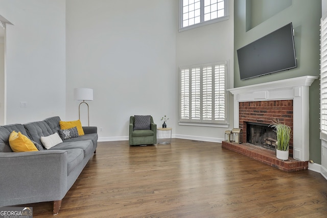 living area with a wealth of natural light, baseboards, and wood finished floors