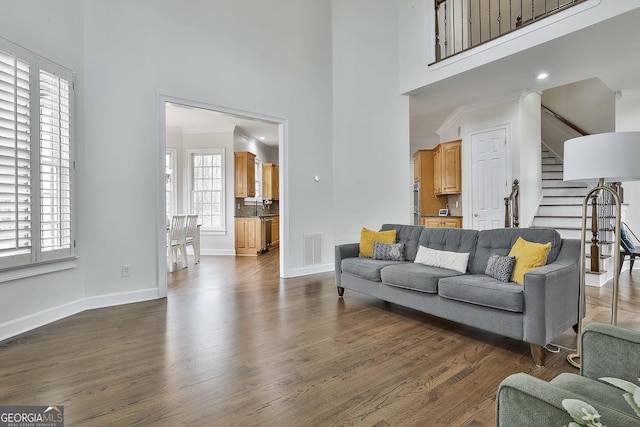 living room with stairs, baseboards, visible vents, and dark wood-style flooring