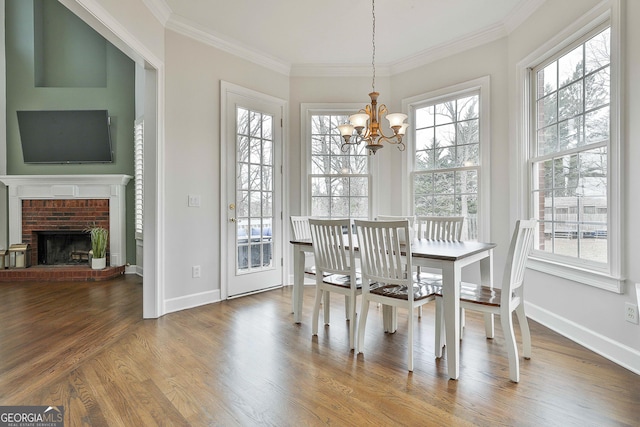 unfurnished dining area with a notable chandelier, wood finished floors, baseboards, and ornamental molding