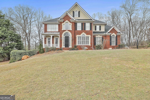 view of front facade featuring a front lawn, brick siding, and a shingled roof