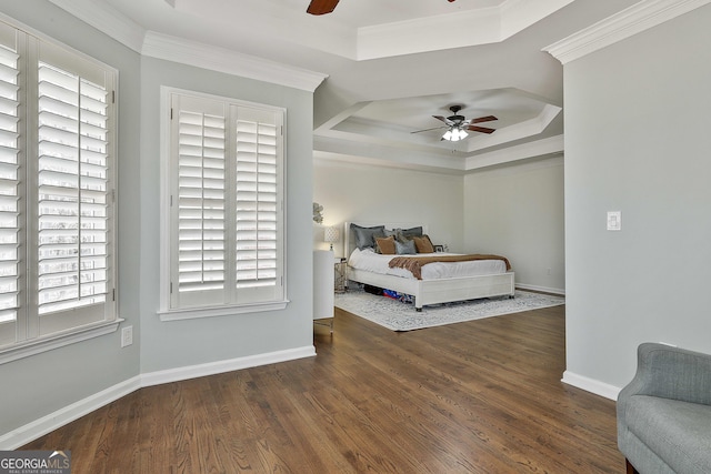 bedroom featuring ornamental molding, a raised ceiling, and wood finished floors