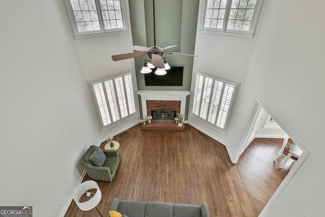 living area featuring a wealth of natural light, visible vents, a ceiling fan, and wood finished floors