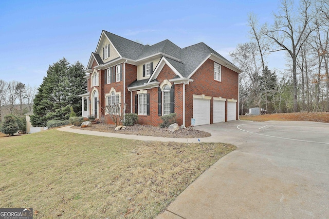 view of front of property with a garage, a front lawn, brick siding, and driveway