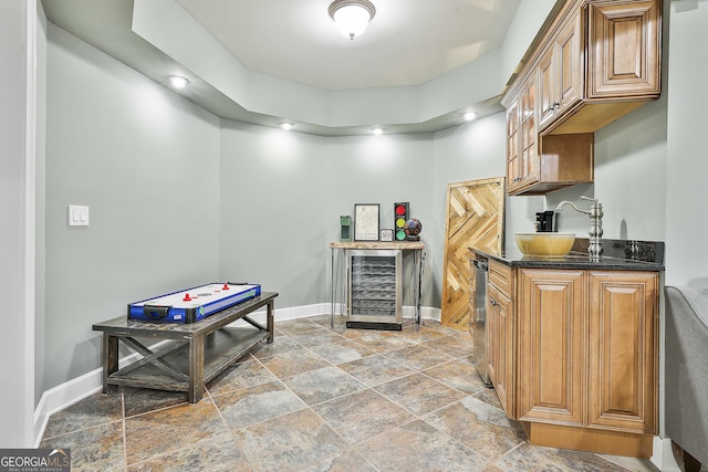 kitchen featuring dark stone countertops, baseboards, recessed lighting, wine cooler, and brown cabinets