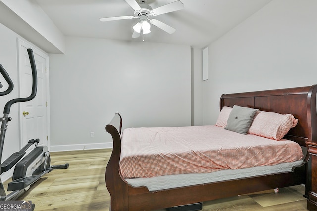 bedroom with a ceiling fan, baseboards, and light wood-type flooring