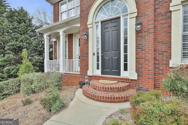 entrance to property featuring brick siding