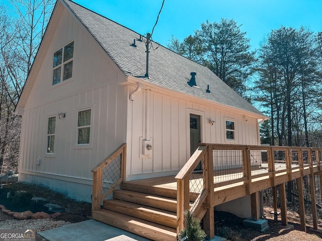 back of house featuring a shingled roof and a deck